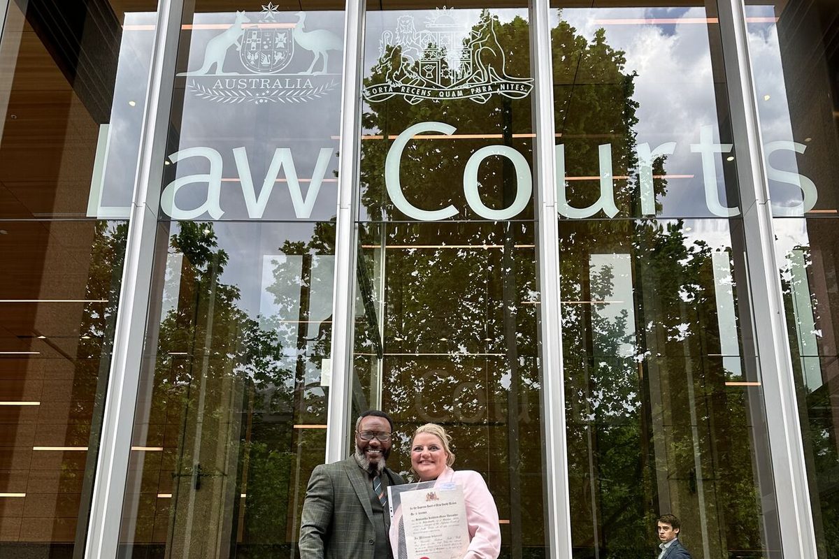 Lovemore Ndou with a client on the steps of the Law Courts building in Sydney